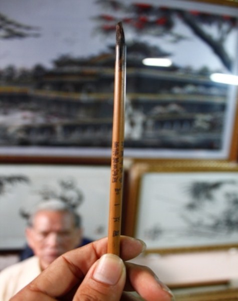 Cây bút lông có khắc chữ Hán trong bộ nghiên mực của vua Khải Định.